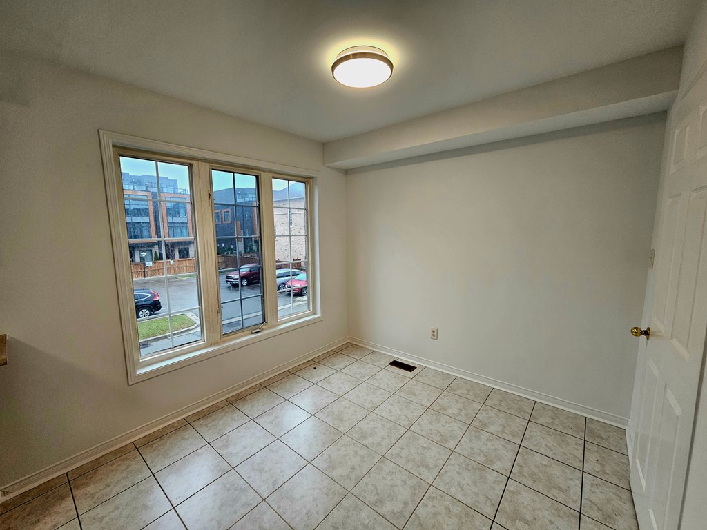 A room with a window overlooking a parking lot.