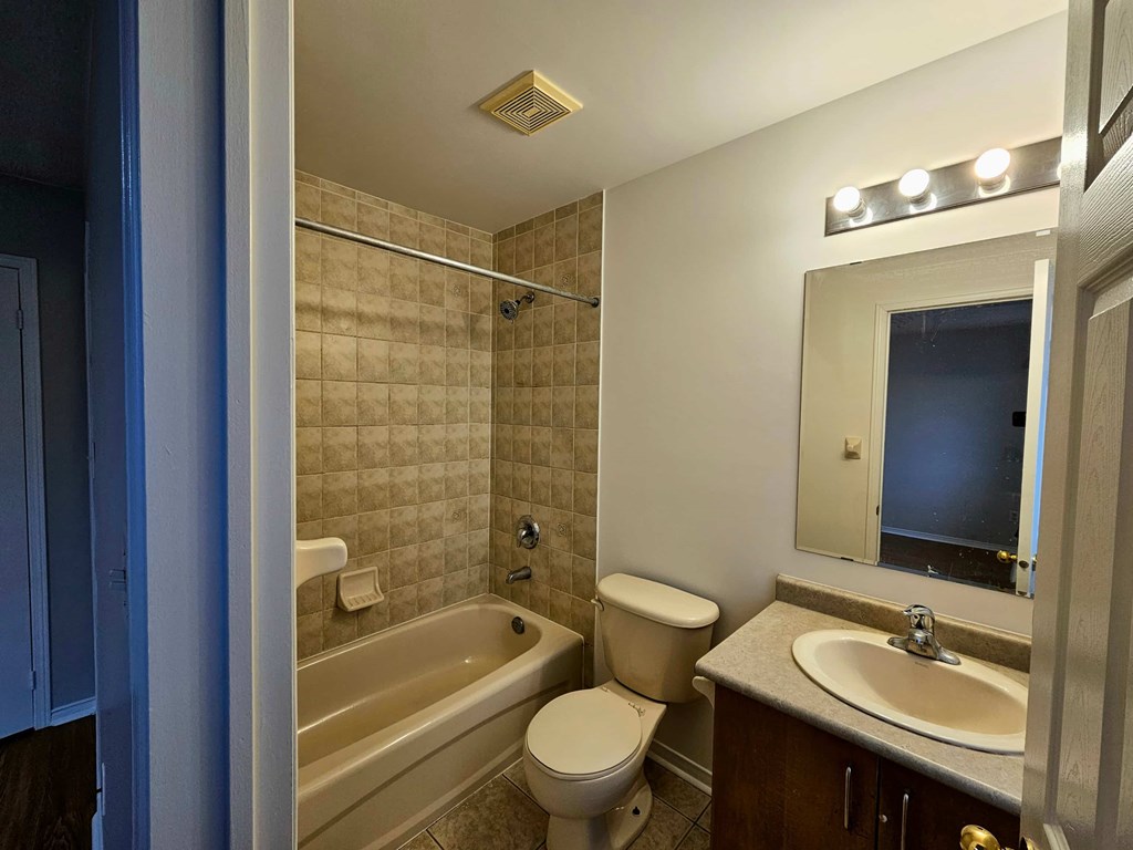 A bathroom with a toilet, sink, and bathtub.