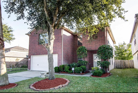 A house with a red brick exterior and a white garage door.