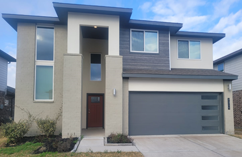 A modern house with a brown door and a grey garage door.