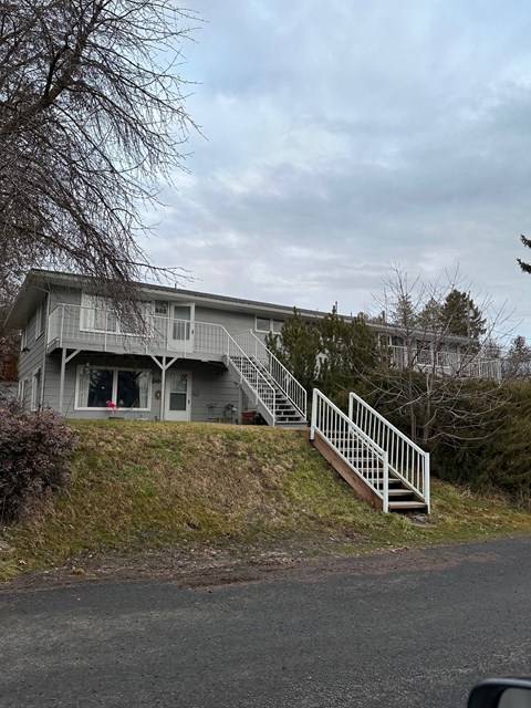 a house on a hill next to a road