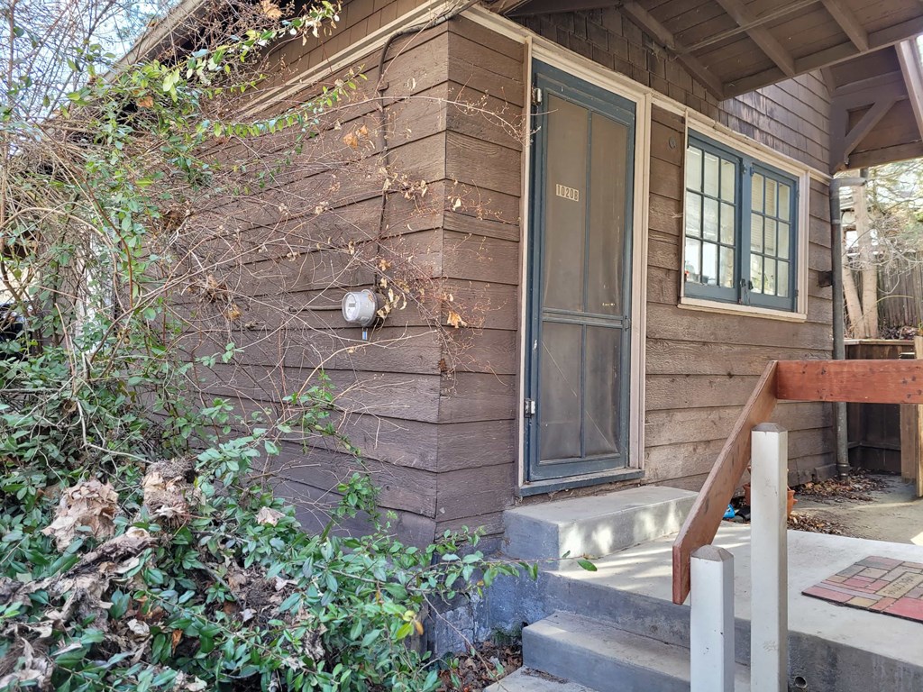 the front of a house with stairs and a window