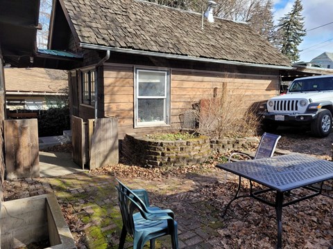 a small house with a patio and a jeep parked outside