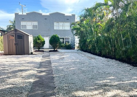 a house with a driveway and a shed in front of it