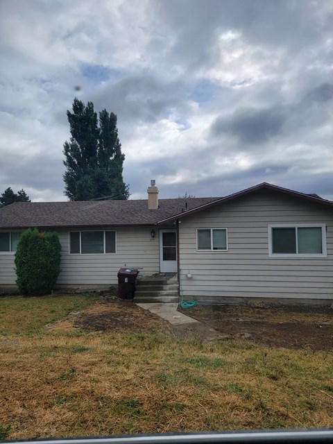 a white house with a stormy sky in the background
