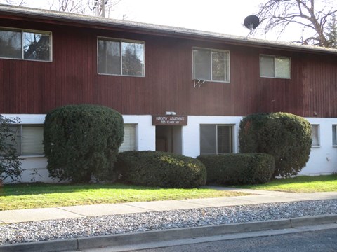a red and white building with hedges in front of it