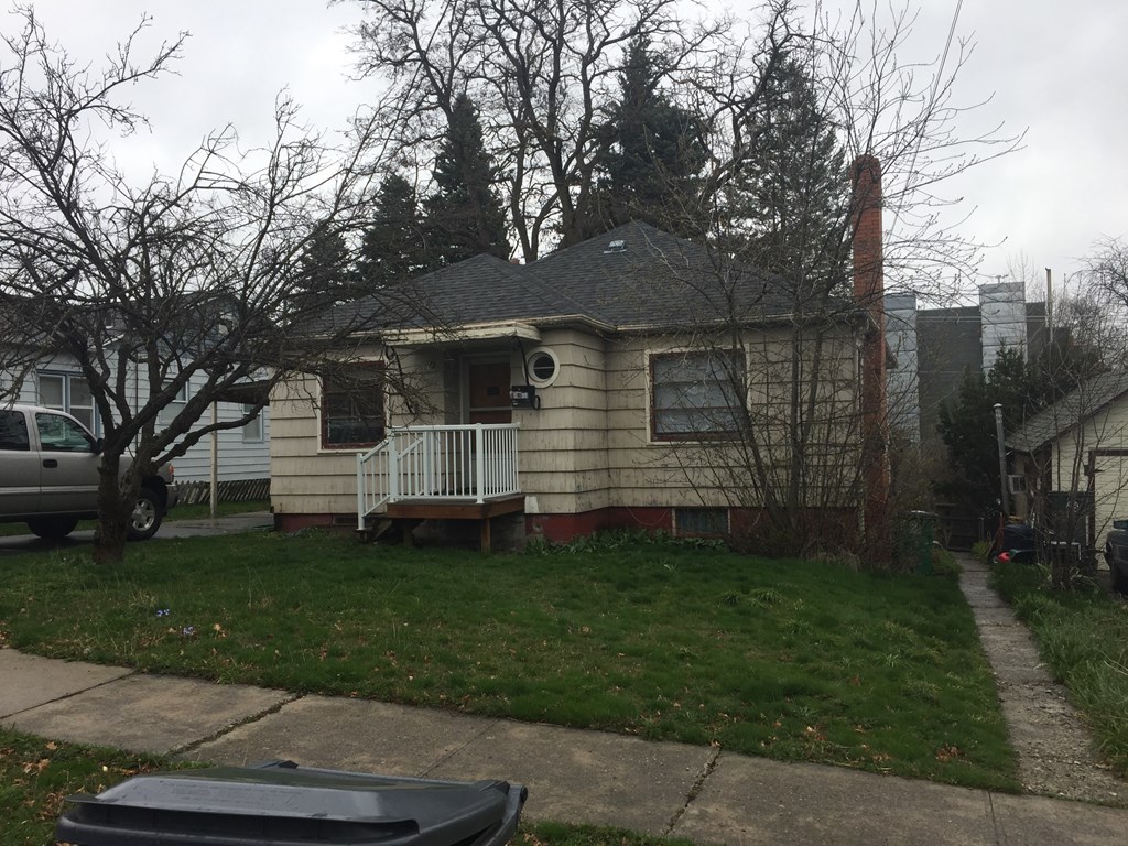 a house with a yard and a car parked in front of it