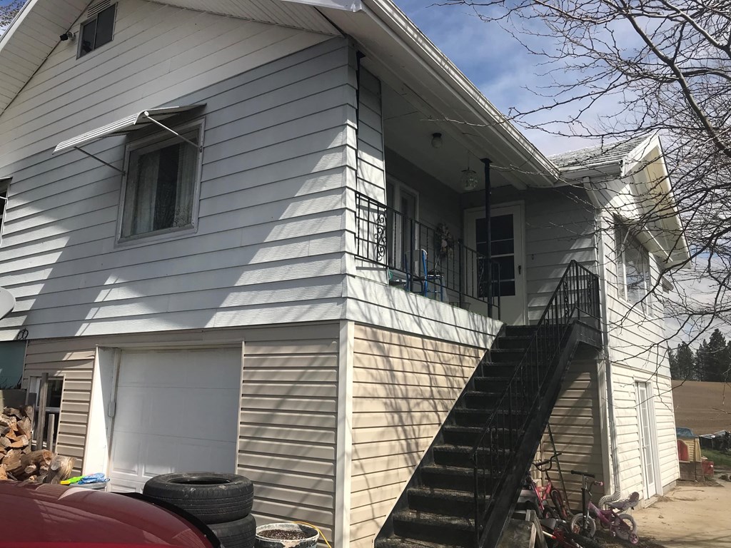 a white house with stairs and a black staircase