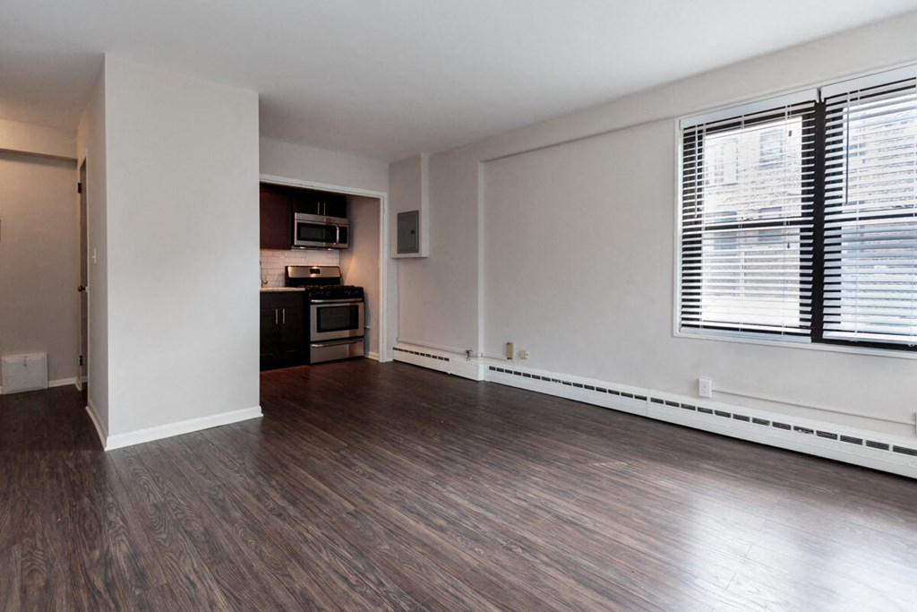 an empty living room with wood flooring and a large window
