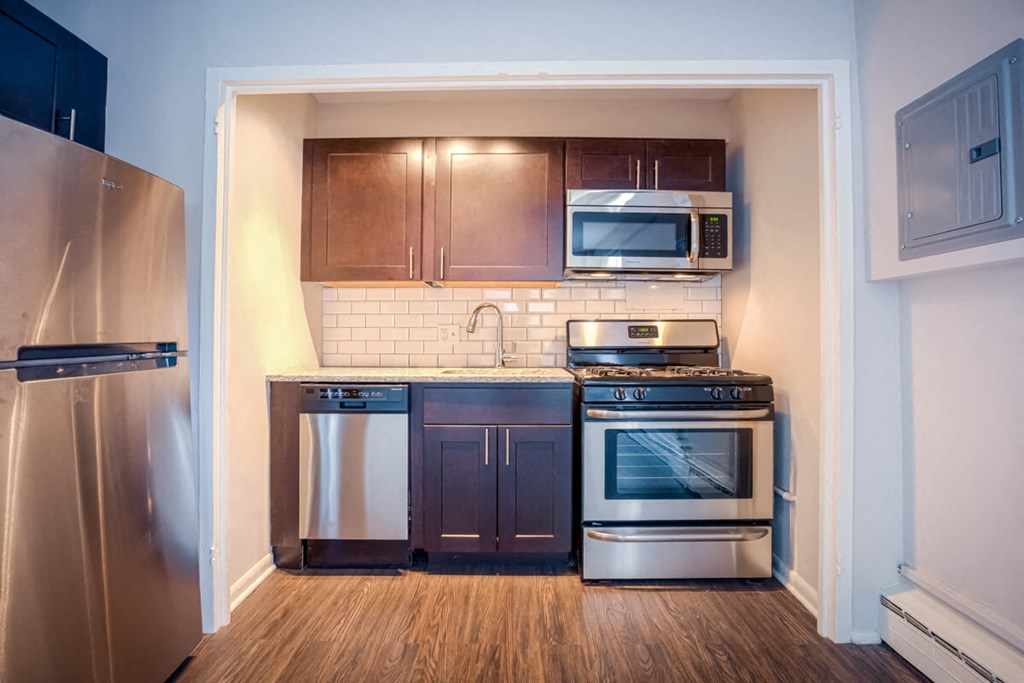a small kitchen with stainless steel appliances and wooden cabinets