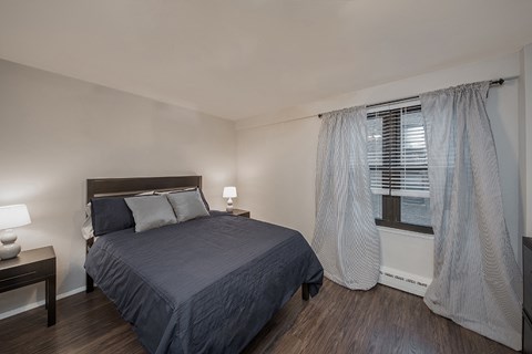 an empty bedroom with a bed and a window
