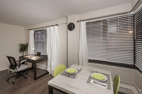a dining room with a table and chairs and a window