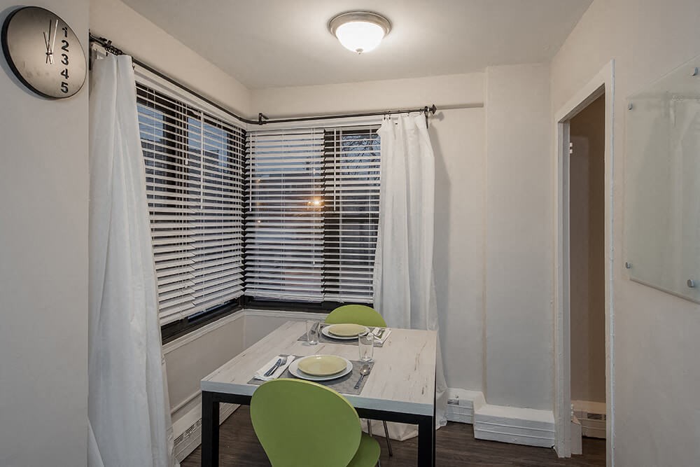 a dining room with a table and chairs and a window