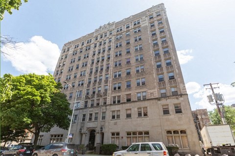 a tall building with cars parked in front of it
