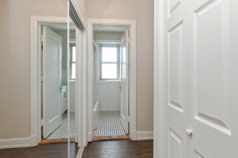 an empty hallway with white doors and a window