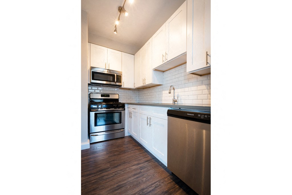 a kitchen with white cabinets and stainless steel appliances