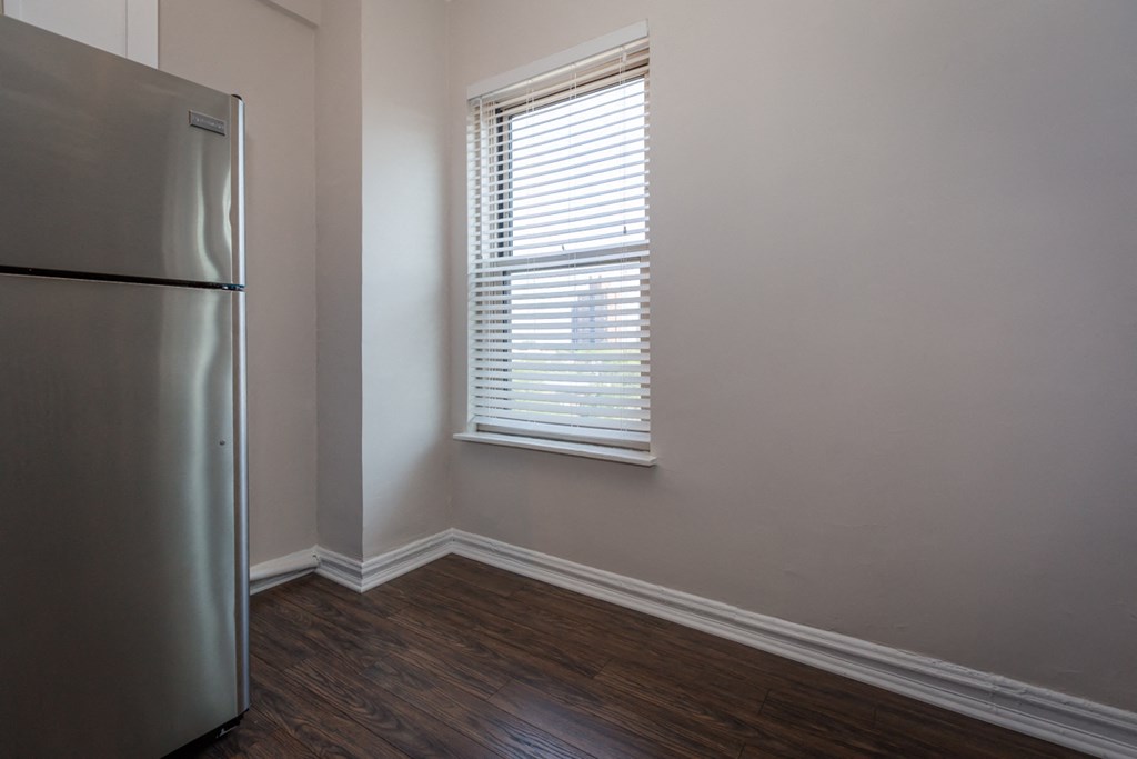 an empty room with a refrigerator and a window