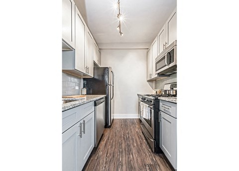 a kitchen with white cabinets and stainless steel appliances