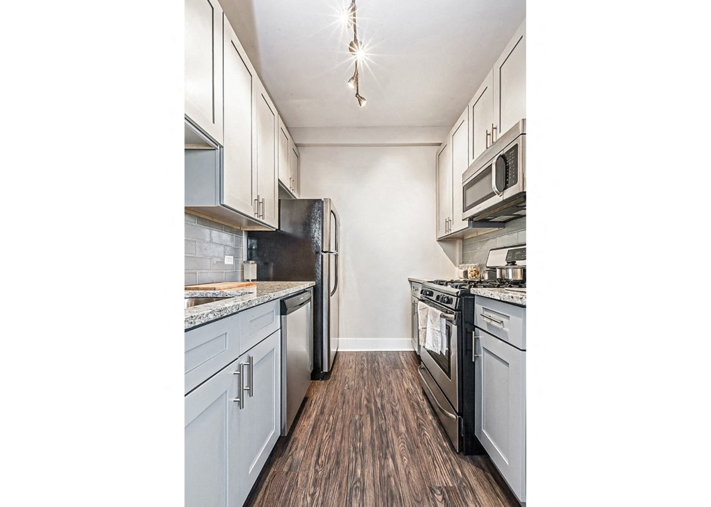 a kitchen with white cabinets and stainless steel appliances