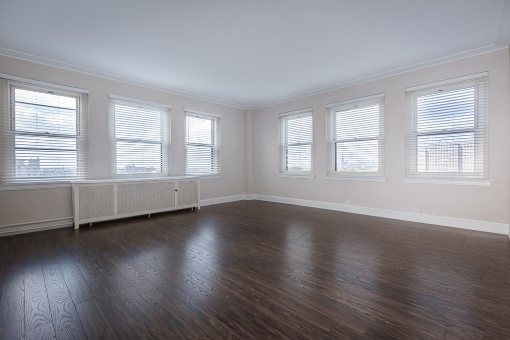 an empty living room with wood floors and windows