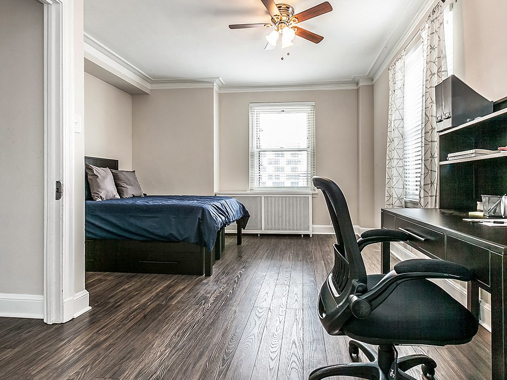a bedroom with a bed and a desk and a chair