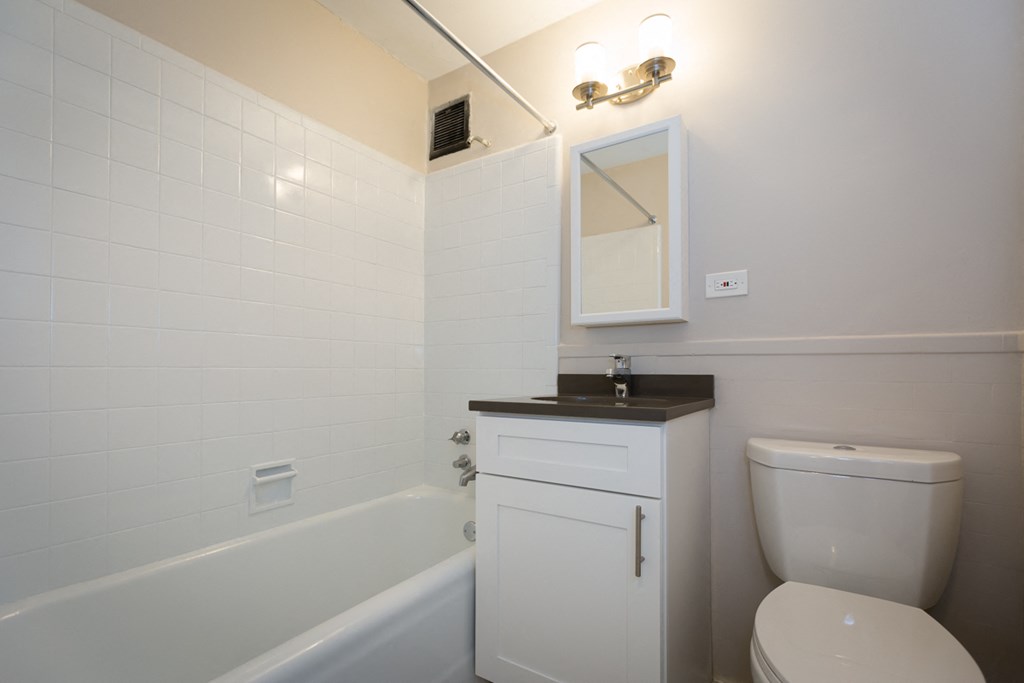 a bathroom with a toilet and a tub and a sink