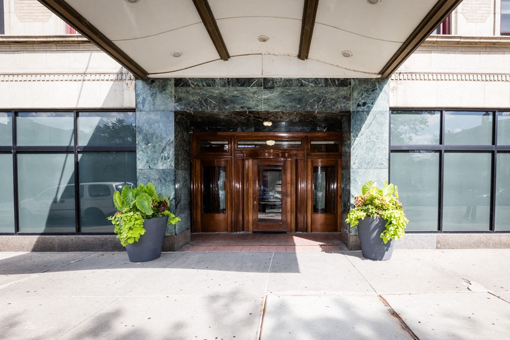the entrance to a building with glass windows and a wooden door