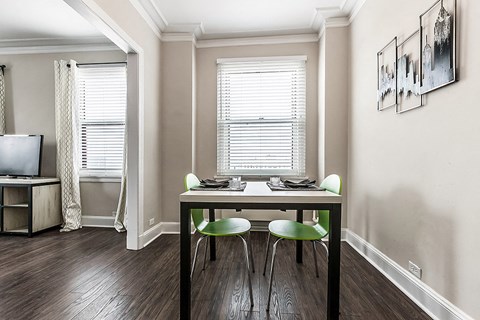 a dining room with a table and chairs and a window