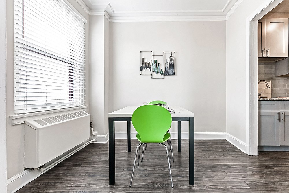 a small dining room with a green chair and a table