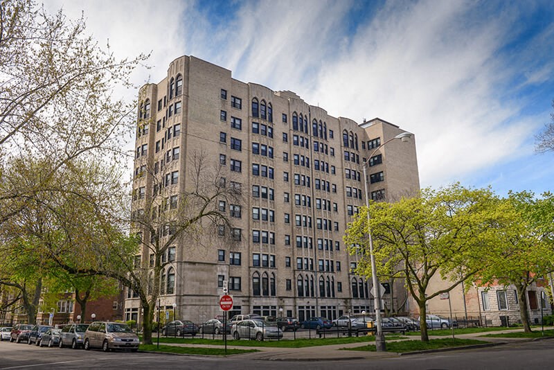 a tall building with cars parked in front of it