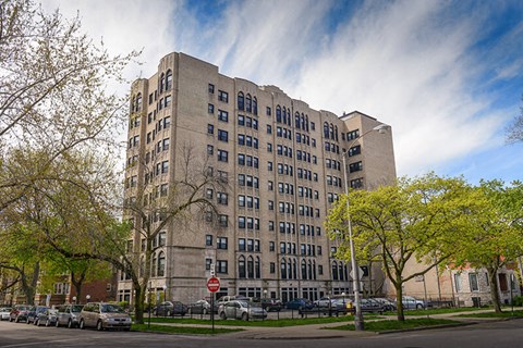 a tall building with cars parked in front of it