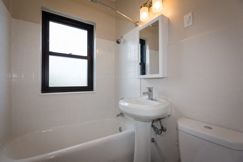 a bathroom with a sink and a tub and a window