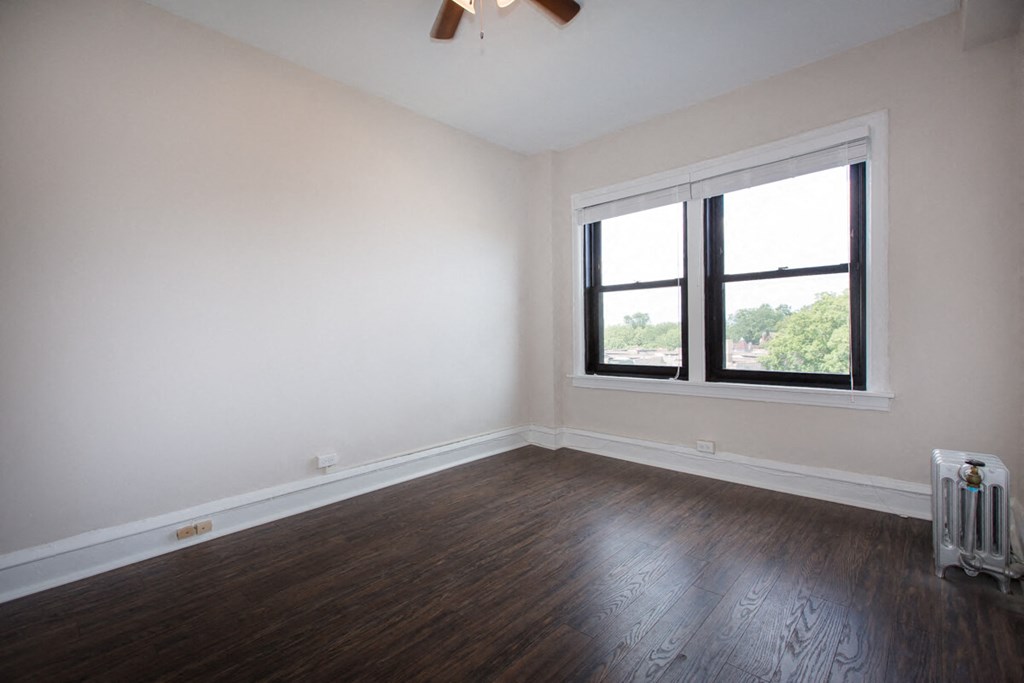an empty room with wood floors and a window
