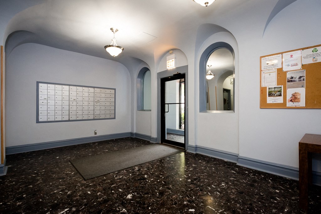 a lobby with a door and a granite floor and white walls