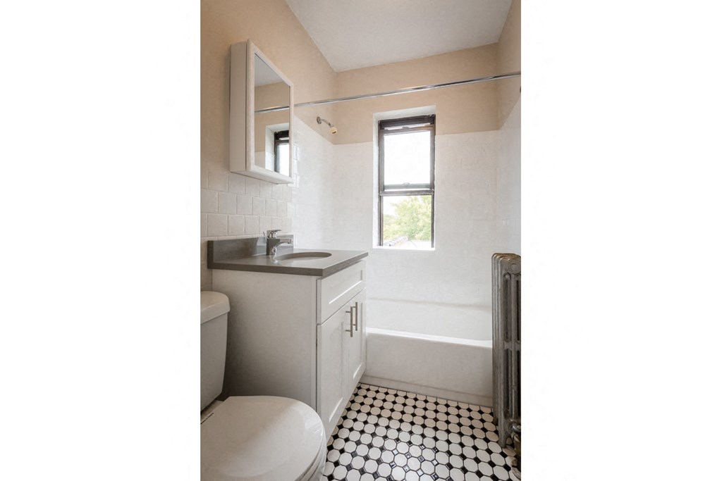 a bathroom with a toilet and a sink and a window