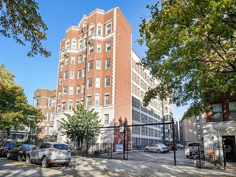 a tall brick building with cars parked in front of it