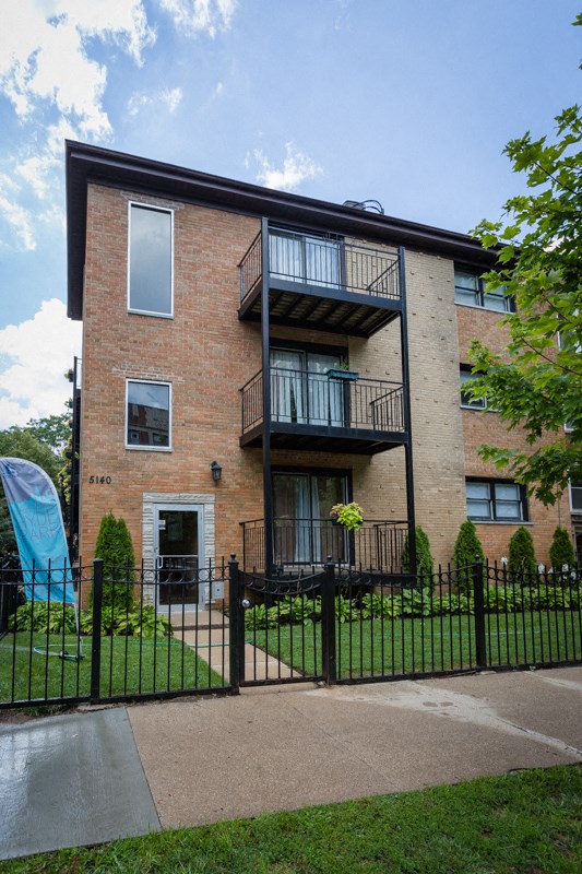 a brick apartment building with a playground in the yard