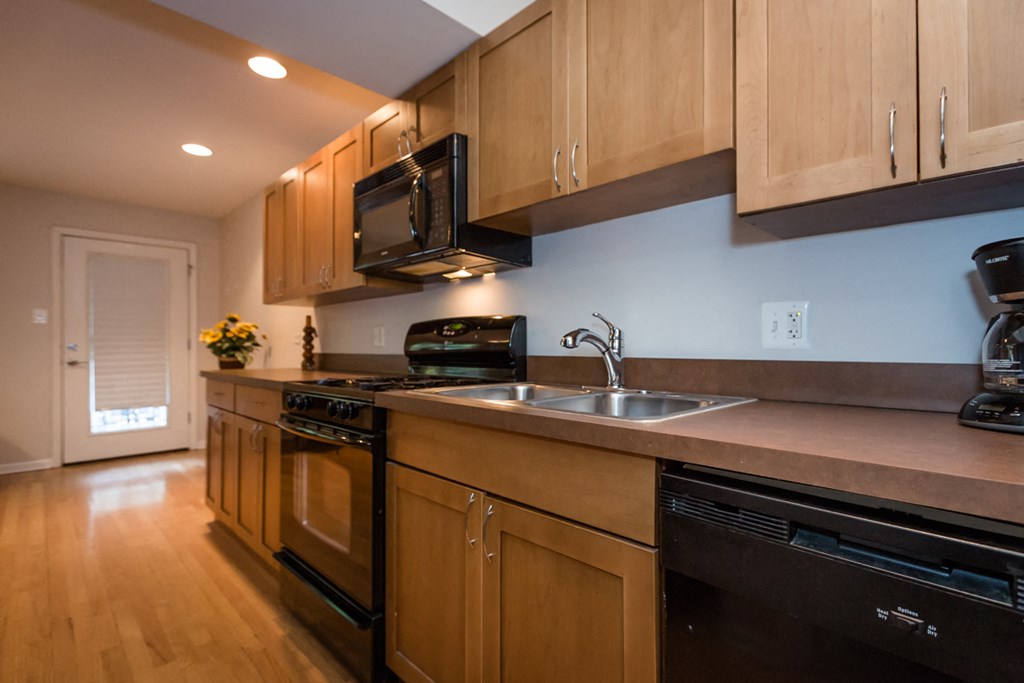 a kitchen with wooden cabinets and a sink and a microwave