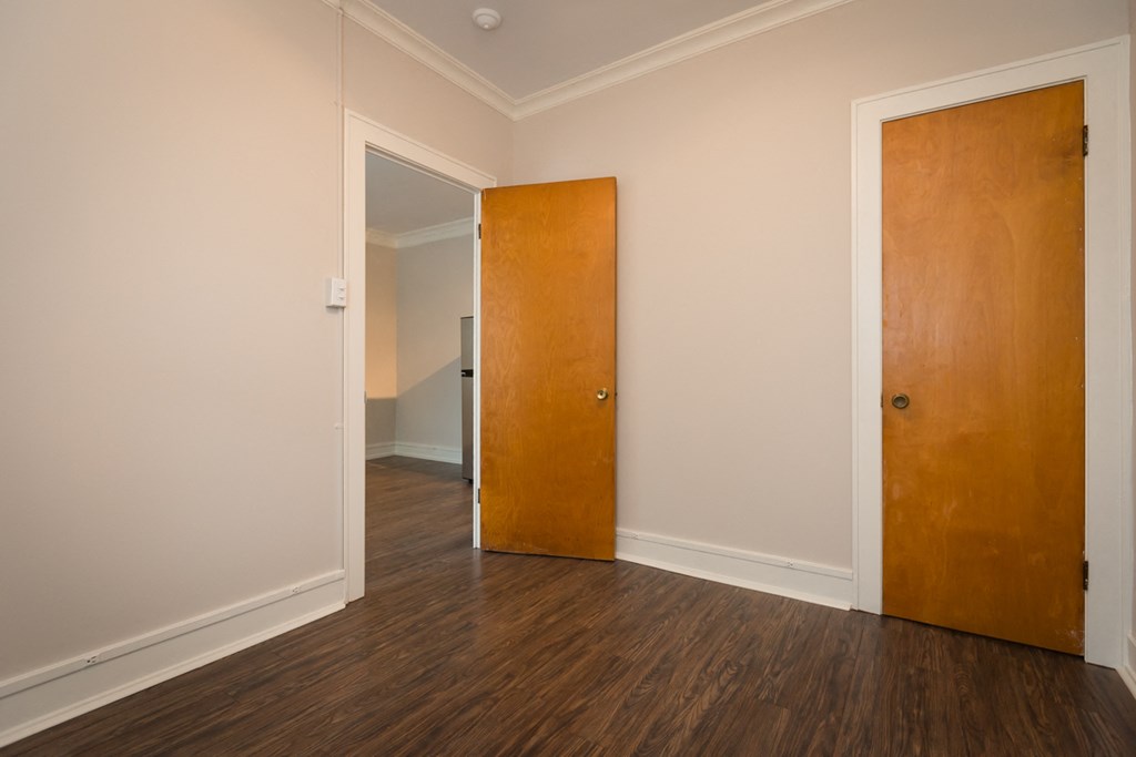 an empty room with a wooden floor and a wooden door