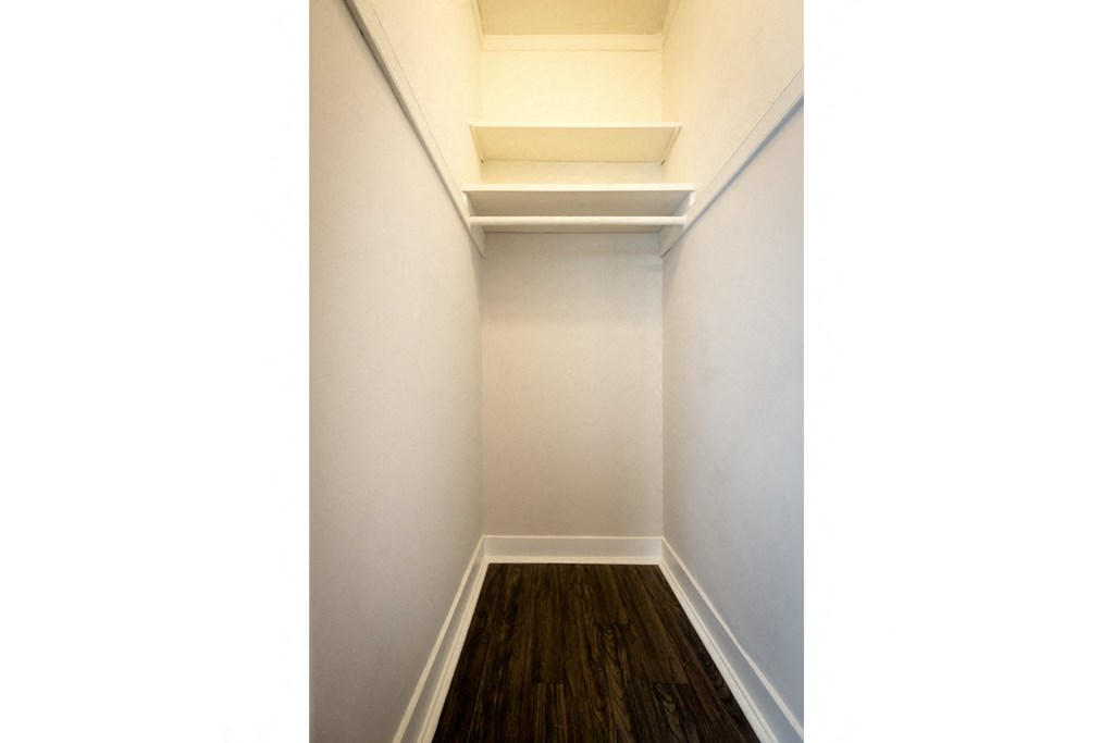 a room with white walls and a wooden floor and a white ceiling with a window