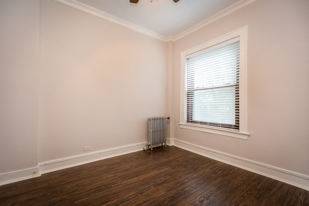 an empty room with a radiator and a window