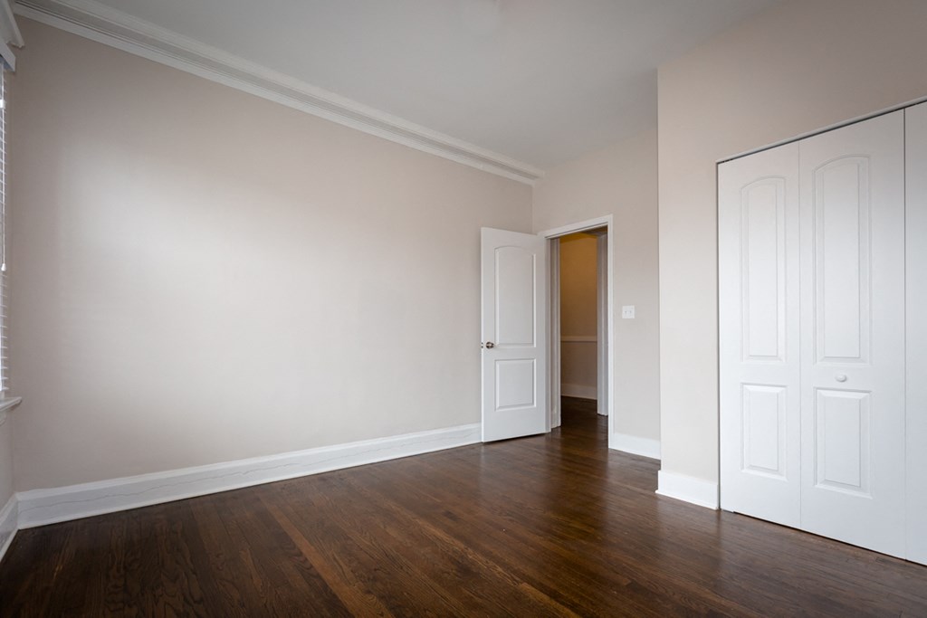 an empty living room with wood floors and white walls
