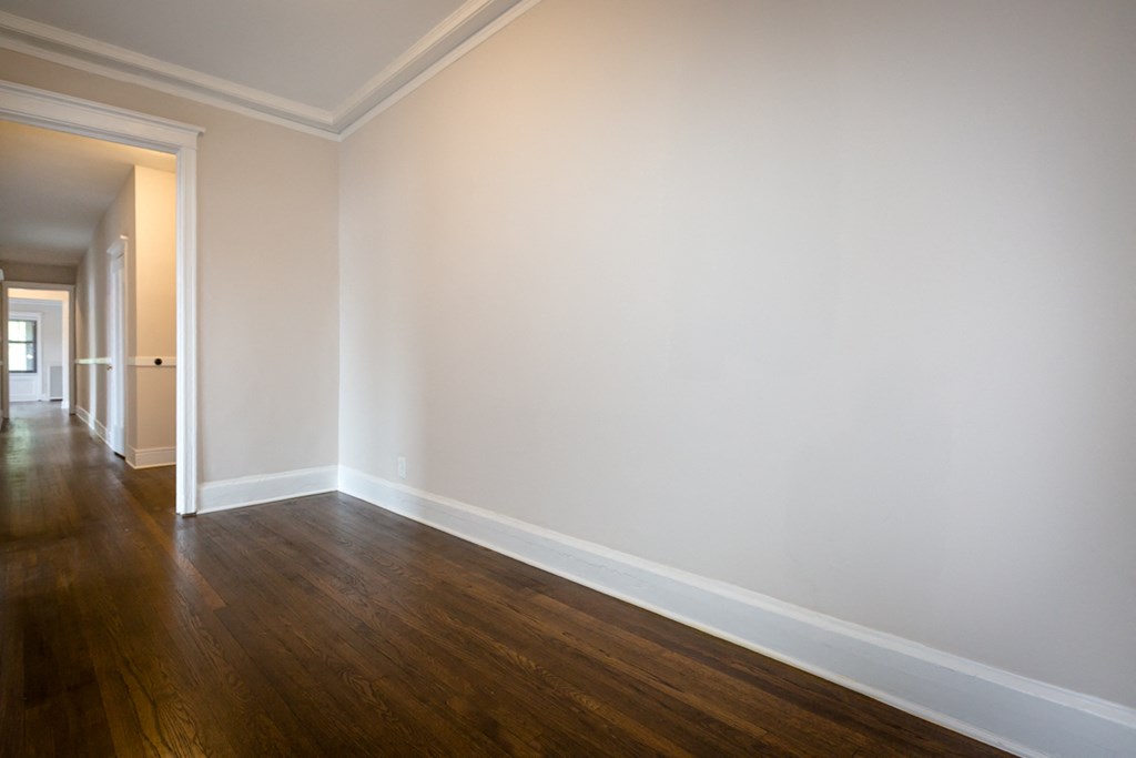 an empty room with wooden floors and white walls