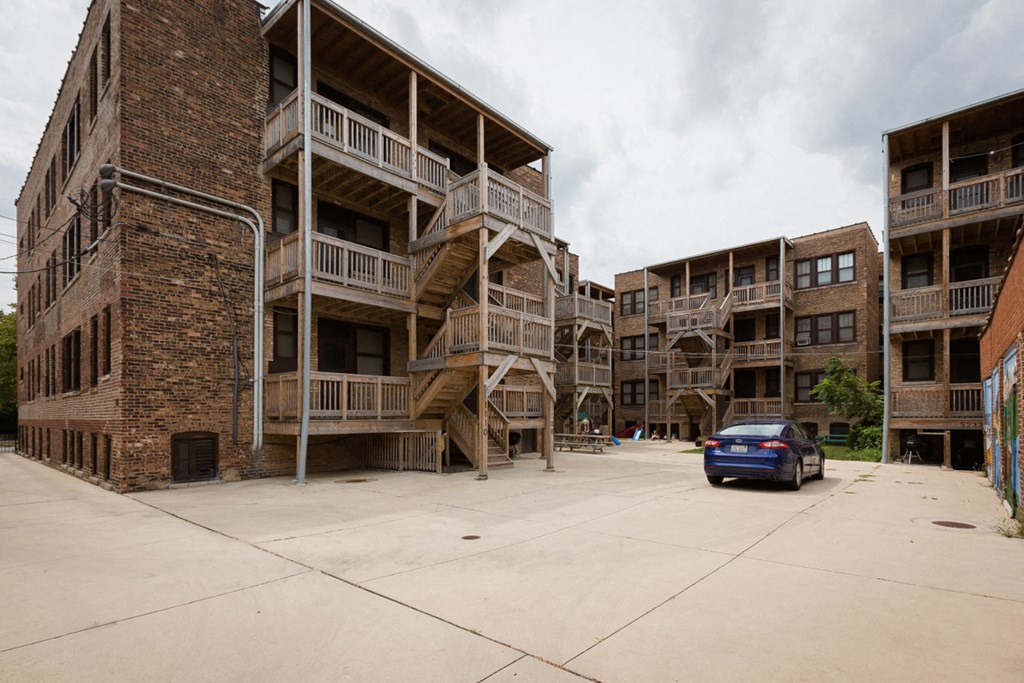 the parking lot of an apartment building with a car parked in front