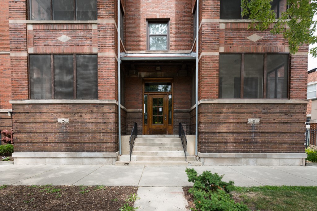 the front of a brick building with a wooden door