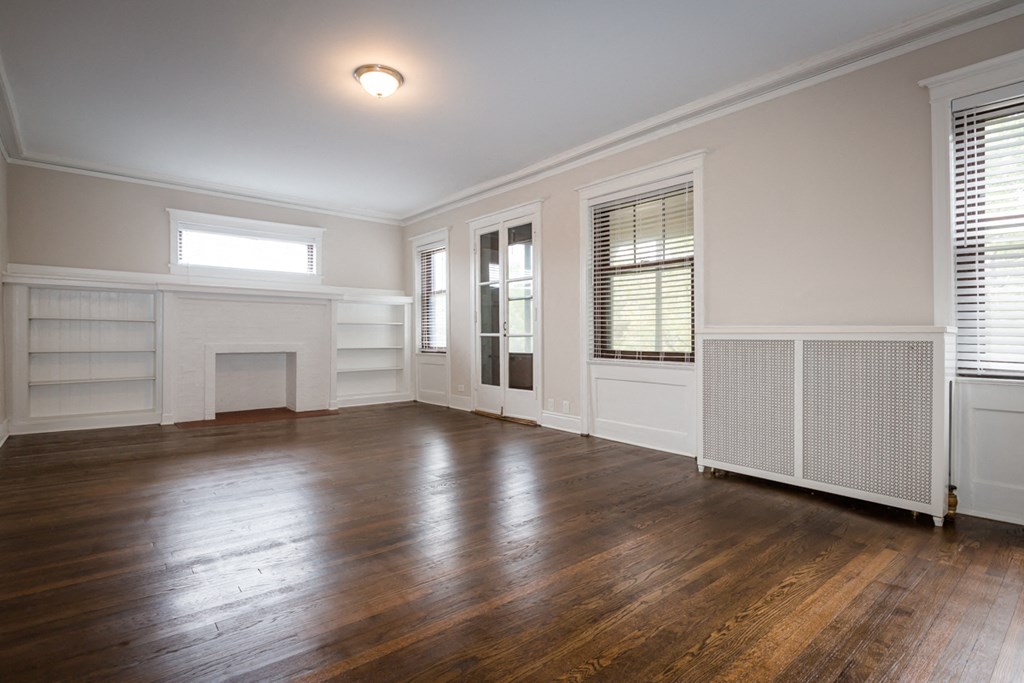 the living room of an empty house with wood floors and a fireplace