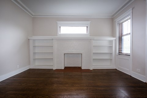 a living room with a fireplace and white shelves