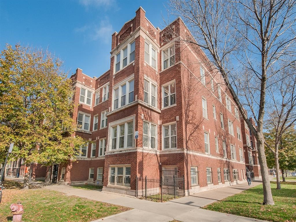 a red brick building with a sidewalk in front of it