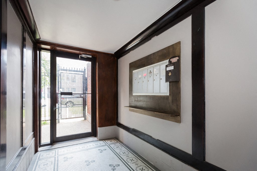 a view of a hallway with a glass door and a bulletin board on the wall