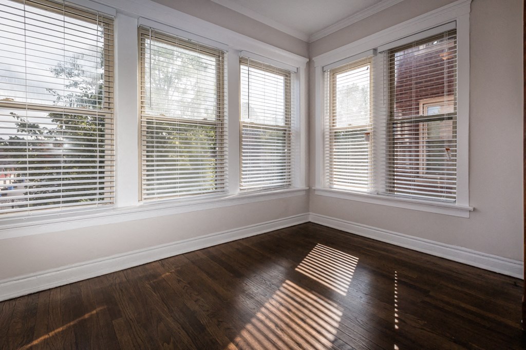 an empty room with wooden floors and windows
